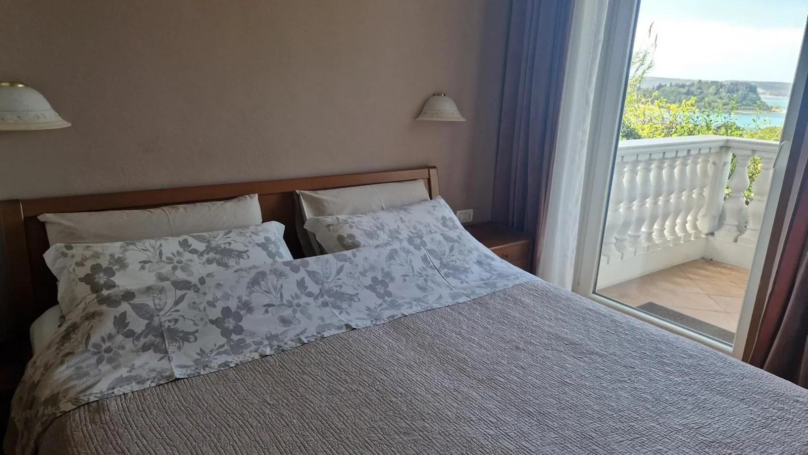 Spalnica apartmaja A z vrati na balkon in pogledom na morje