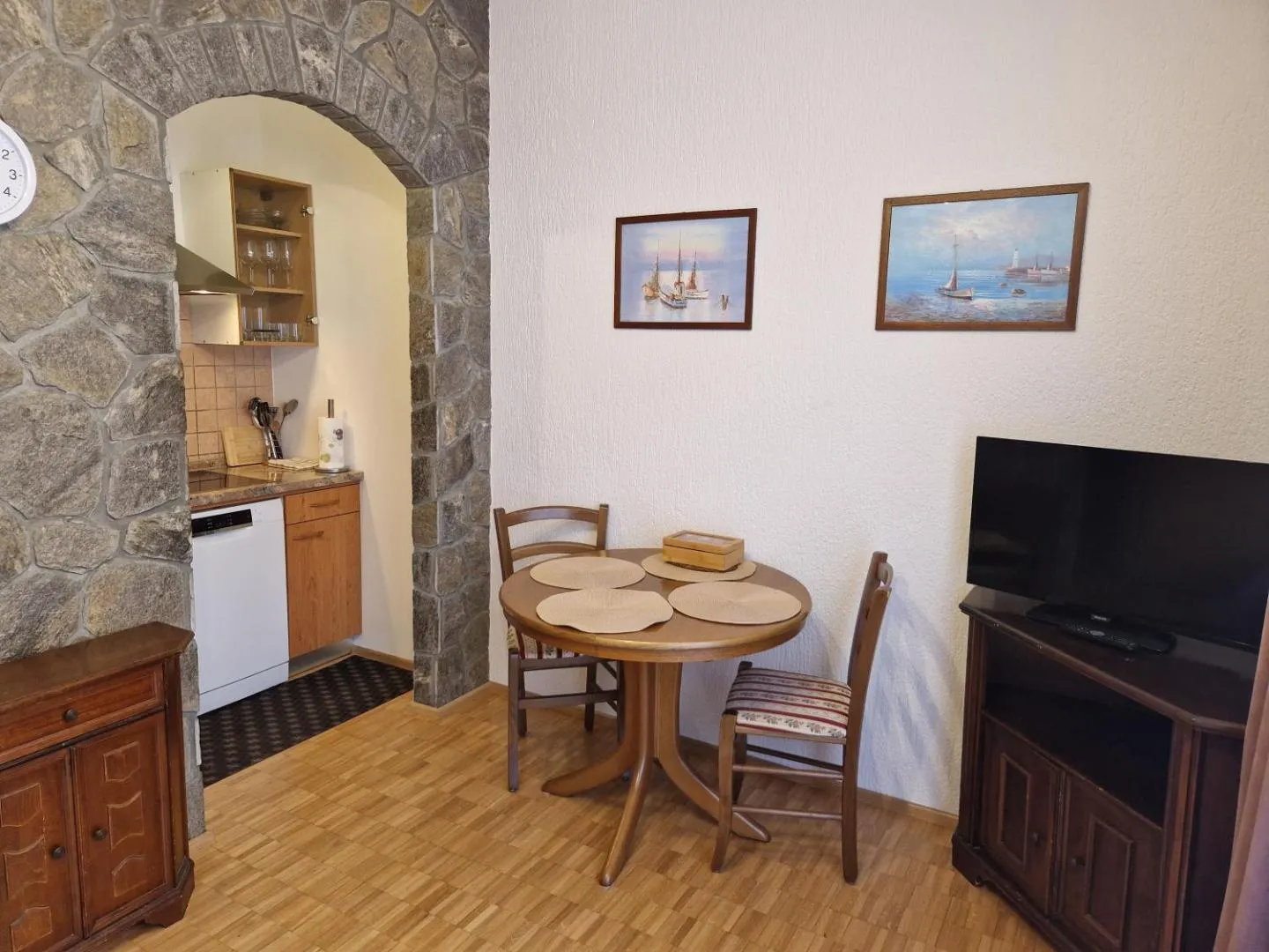 Jedilni kotiček z okroglo mizo, zadaj kuhinja